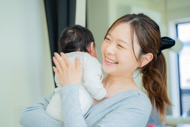 赤ちゃんを抱っこしながら過ごす産後ママの様子｜産後骨盤矯正の相場を知りたい方へ